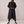 Lillian long trench coat in Black on a light gray studio backdrop