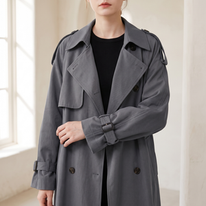 Close view of the lapels, storm flap, buttons and buckled cuff of the Lillian long trench coat in Gray