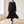Lillian long trench coat in Black worn open while walking across a bright room