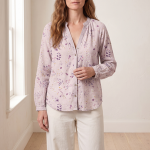 Lucille floral V neck blouse in Pink by a window in a bright room