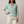 Lucille floral V neck blouse in Turquoise on a light gray studio backdrop