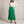 Margot pleated maxi skirt in Green on a light gray studio backdrop