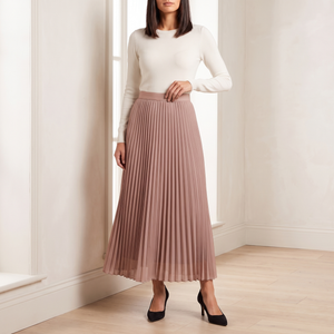 Margot pleated maxi skirt in Dusty Rose worn by a window in a bright room
