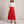 Margot pleated maxi skirt in Red on a light gray studio backdrop