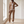 Marianne tracksuit set in Camel worn by a window in a bright room