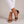 Martina low block heel sandals in Black worn with ankles crossed on a light gray studio backdrop