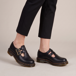 Matilda leather Mary Jane flats in Black worn with cropped black trousers on a light gray studio backdrop