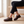 Matilda Mary Jane flats in Brown worn seated on a pale oak bench, showing the ridged sole