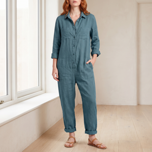 Nerea linen blend jumpsuit in Blue, worn by a window in a bright room