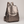 Pauline leather backpack in Bronze standing upright on a light gray studio backdrop