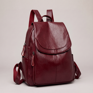 Pauline leather backpack in Wine standing upright on a light gray studio backdrop