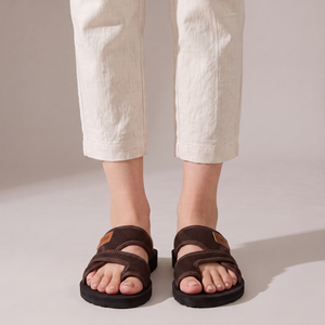 Pilar toe loop slide sandals in Brown seen from the front on a light gray studio backdrop