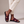Pilar toe loop slide sandals in Burgundy with one foot crossed at the ankle on a light gray studio backdrop