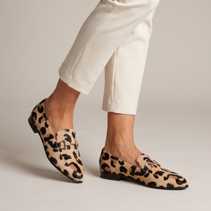 Portia leopard print loafers with gold horsebit on a light gray studio backdrop