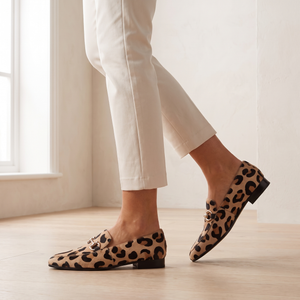 Portia leopard print loafers worn with cream cropped trousers, walking across an oak floor