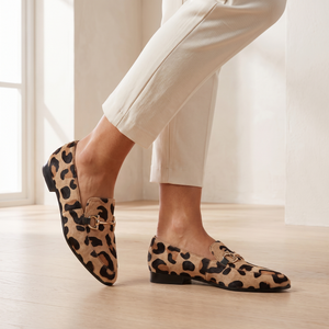 Close view of the Portia leopard print loafers showing the pointed toe and gold horsebit, worn with cream cropped trousers
