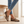 Portia leopard print loafers worn with cropped jeans beside an oak bench