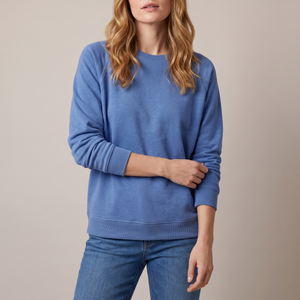 Rita raglan crew neck sweatshirt in Blue on a light gray studio backdrop