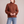 Romane chunky knit turtleneck sweater in Brown with jeans on a light gray studio backdrop