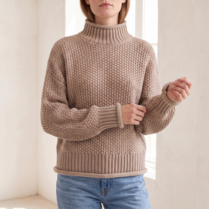 Close view of the Romane chunky knit turtleneck sweater in Beige showing the ribbed collar and cuff