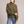 Romane chunky knit turtleneck sweater in Olive with jeans on a light gray studio backdrop