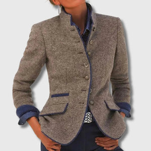 Rosamund wool blazer in Brown with navy edging, worn over a dark shirt with hands at the hips