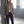 Woman in the Rosamund brown wool blazer standing beside a steel column in a sunlit warehouse