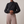 Solange draped mock neck blouse in Black on a light gray studio backdrop