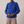 Solange draped mock neck blouse in Blue on a light gray studio backdrop