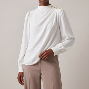Solange draped mock neck blouse in White on a light gray studio backdrop