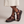 Soledad platform sandals in Burgundy with one foot crossed over the other on a light gray studio backdrop