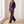 Suzanne half zip knit set in Purple worn walking by a window