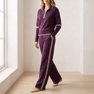 Suzanne half zip knit set in Purple worn walking by a window