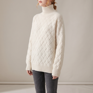 Verity lattice knit turtleneck sweater in Ivory worn with gray jeans on a light gray studio backdrop