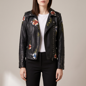 Victoire embroidered leather moto jacket in Black worn open over a white T shirt on a light gray studio backdrop