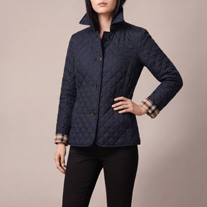 Winona quilted jacket in Navy Blue on a light gray studio backdrop